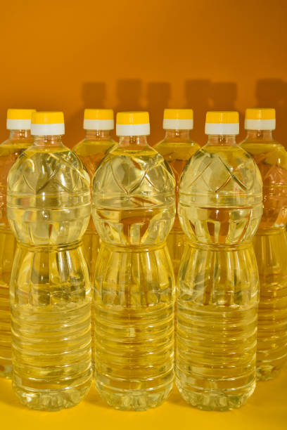 オレンジ色の背景に天然の洗練されたヒマワリ植物油のペットボトル - ヒマワリ種子油 ストックフォトと画像