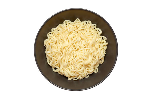 istock Noodles instant, cooked, in dark deep bowl, top view, isolated on white background with clipping path. 1388589219