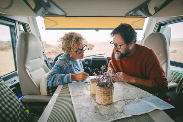 istock Happy Couple Looking At Map Sitting In Motor Home 1388590609