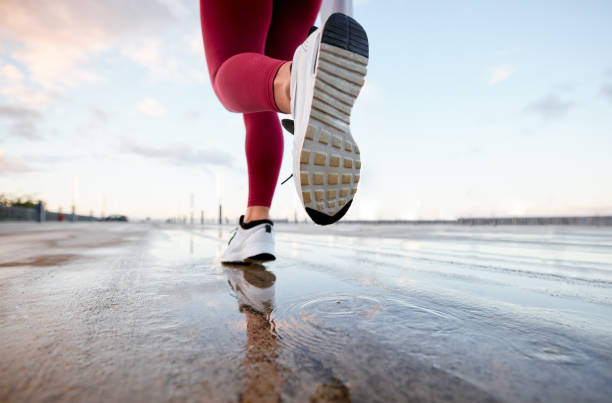 shot of an unrecognizable person running in the city - base runner imagens e fotografias de stock