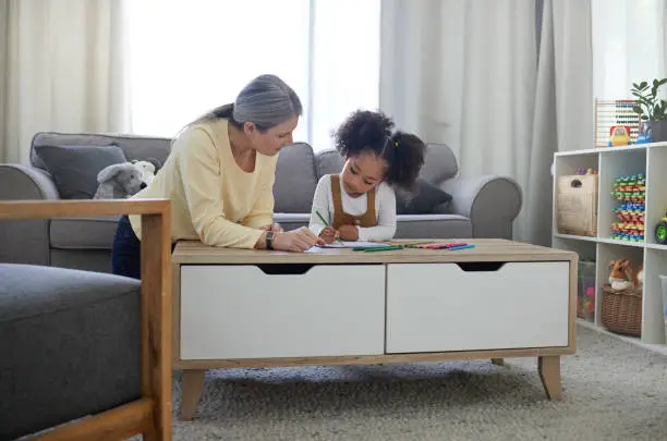 Photo of Shot of a little girl drawing in a psychologists office