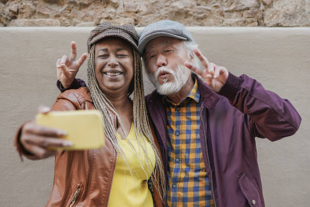 istock Multiracial senior couple taking a selfie using mobile phone 1388594298