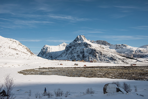 View of snowy mountain range on coastline in winter on sunny day at Lofoten islands, Norway