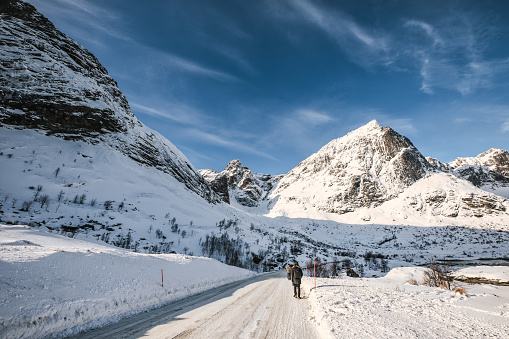 View of snowy mountain range and the road in winter on sunny day at Lofoten islands, Norway