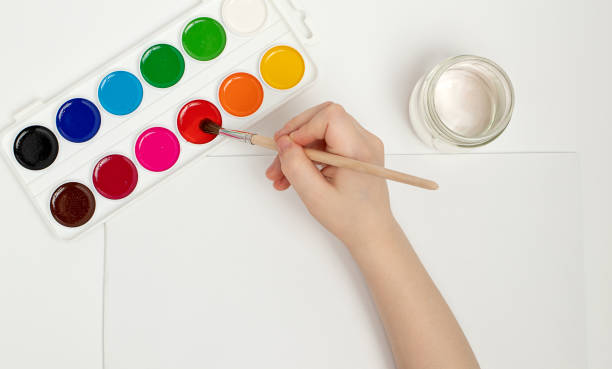 istock Children's hands begin to draw at a table with art supplies, top view 1388594529