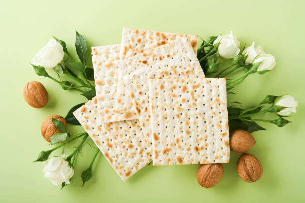 istock Passover celebration concept. Matzah, red kosher wine, walnut and spring beautiful rose flowers. Traditional ritual Jewish bread on light green background. Passover food. Pesach Jewish holiday. 1388595837