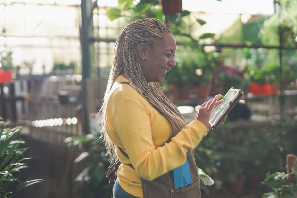 istock African woman working inside garden greenhouse while using digital tablet 1388597851