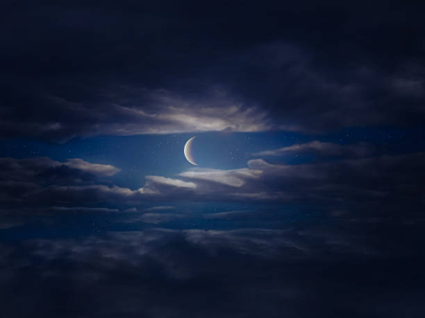 istock Moon in the night sky shines through dark clouds 1388597899