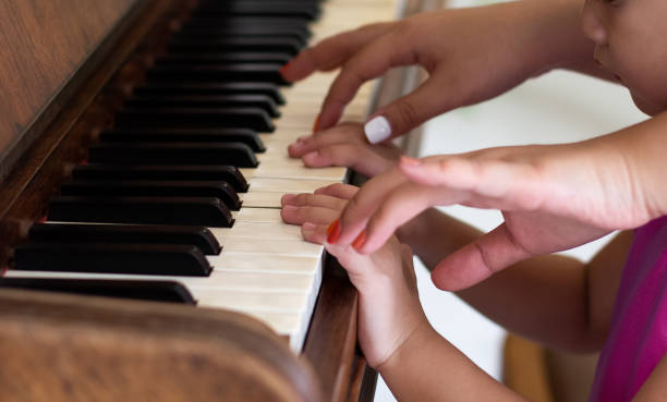 doświadczony mistrz gry na pianinie pomaga uczniowi, palcom - plucking an instrument zdjęcia i obrazy z banku zdjęć