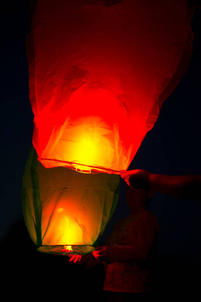 istock Two fiery Chinese lanterns in the hands. Night. Make a wish. Memory. Deceased. 1388598952