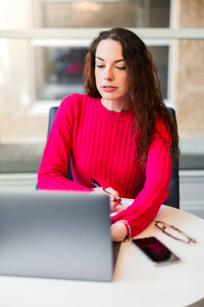 donna che usa il laptop con un volto serio o preoccupato. forse problemi sul lavoro, con la telegrafia o le finanze - wireless telegraphy foto e immagini stock