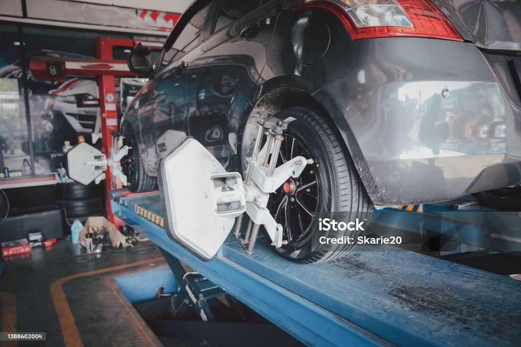 Car wheel balancer calibrate with laser reflector attach on each tire to center driving adjust. Car in auto service. Balancing tire wheel machine. Car Stock Photo