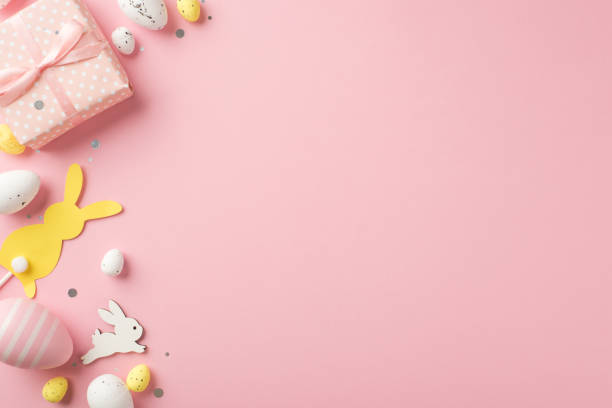 istock Top view photo of easter decorations giftbox sequins easter bunnies pink yellow and white easter eggs on isolated pastel pink background with blank space 1388602307