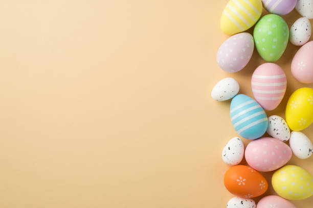 istock Top view of few multicolored pastel and white middle and small eggs situated on isolated beige background with copyspace 1388602348