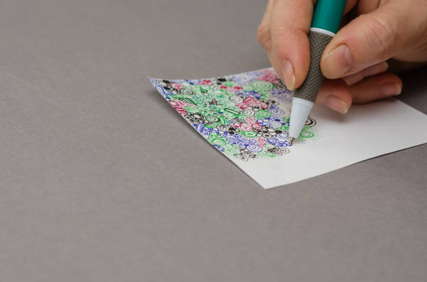 istock A woman's manicure-less hand draws an abstract drawing with a pen. 1388603472