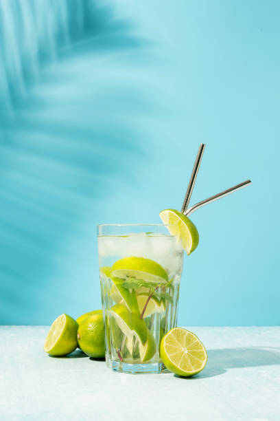 fresh summer caipirinha cocktail on blue background fresh summer caipirinha cocktail on blue background with green fruit lime on table rum photos stock pictures, royalty-free photos & images