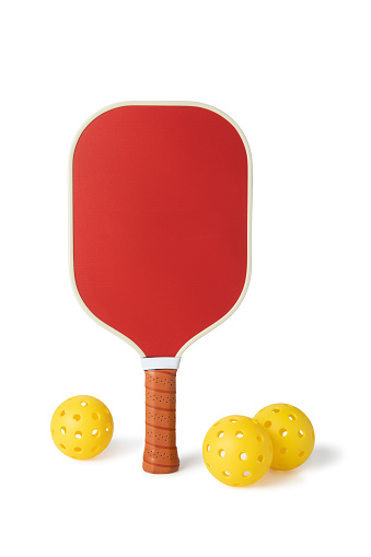 This is a photograph taken in the studio of a pickleball paddle and balls Isolated on a White Background