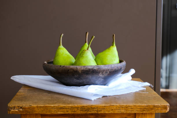 peras verdes en un antiguo plato antiguo de arcilla sobre una mesa de madera. plantilla de comida marrón oscuro. espacio vacío. - 6184 fotografías e imágenes de stock