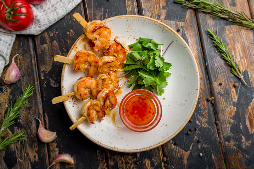 tiger shrimp kebab with china sauce on old wooden table top view