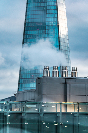 Ventilation system with chimneys and ducts on the roof of a a modern building