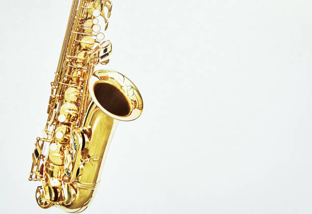 istock Bright, shiny alto saxophone on subtly patterned white background 1388610144