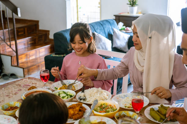 malajska muzułmańska rodzina modląca się przed obiadem w domu - muslim festival zdjęcia i obrazy z banku zdjęć