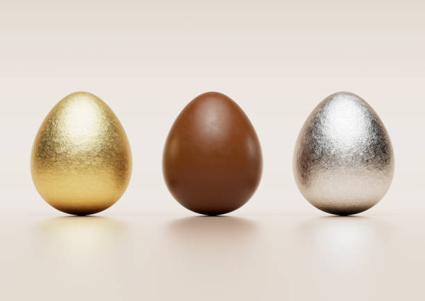 istock Milk chocolate easter eggs with gold and silver Aluminium foil on pale background. 1388619627