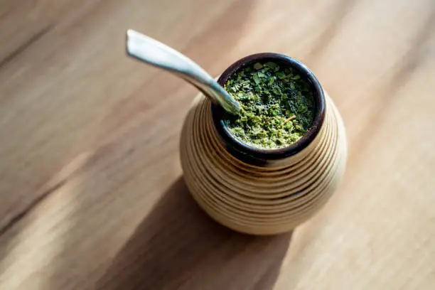 Healthy infused drink, energy boosting beverage on neutral wooden table.