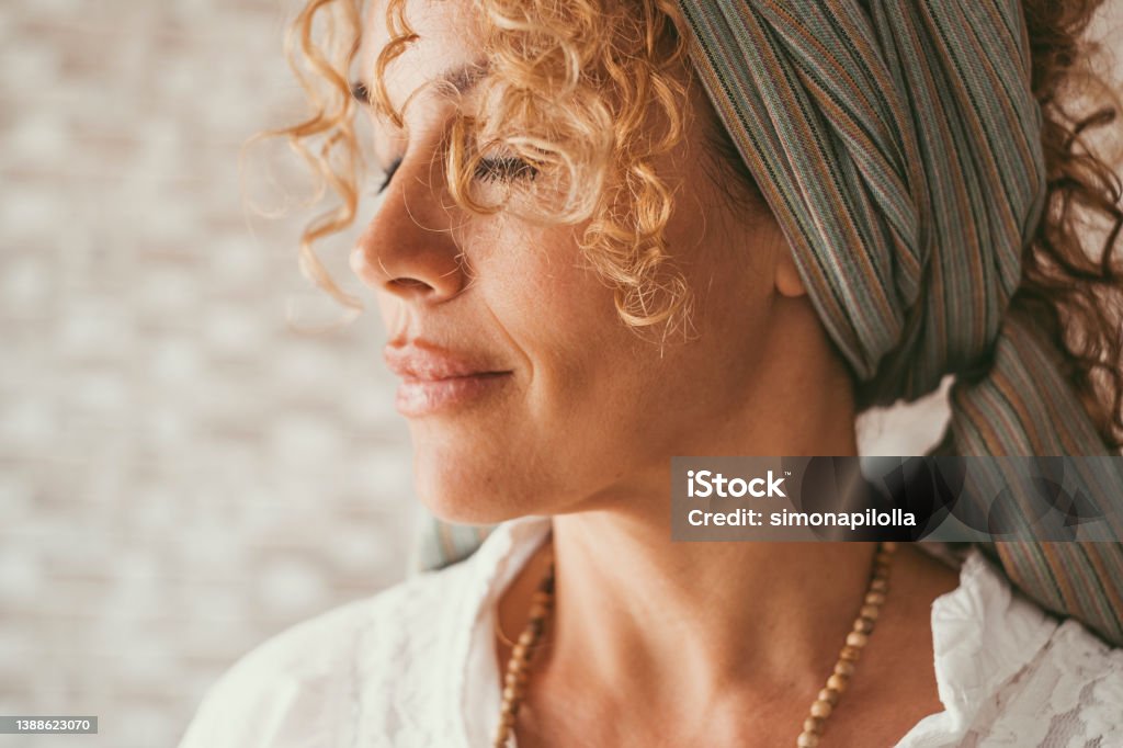 Wellbeing and healthy lifestyle serene woman expression. Side portrait of female people in meditation. Middle age pretty lady with closed eyes and peaceful feeling. Concept of happiness inside Mature Women Stock Photo