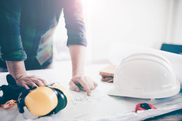 istock Construction manager at his desk studying the architectural drawings 1388624948