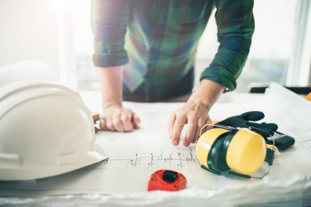 istock Construction manager at his desk studying the architectural drawings 1388624976