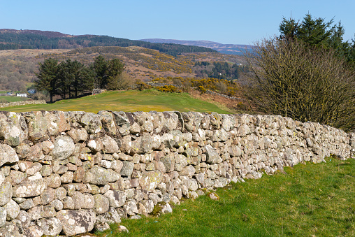 Old stone wall in the Scottish countryside on a beautiful Spring morning.  Sandyhills Beach, Dalbeattie, Scotland.