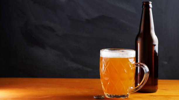 istock Beer mug on wooden table, black background 1388627349