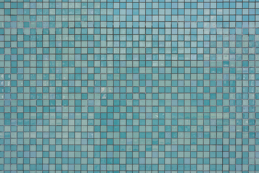 Close up of a a wall, tiled with square ceramic tiles