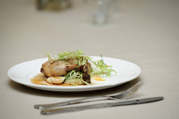 Close-up of chicken with egg slices and herbs served in plate with cutlery on table at wedding ceremony