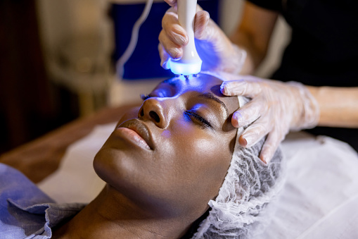 Mujer en el spa recibiendo un tratamiento de ultrasonido en su cara photo