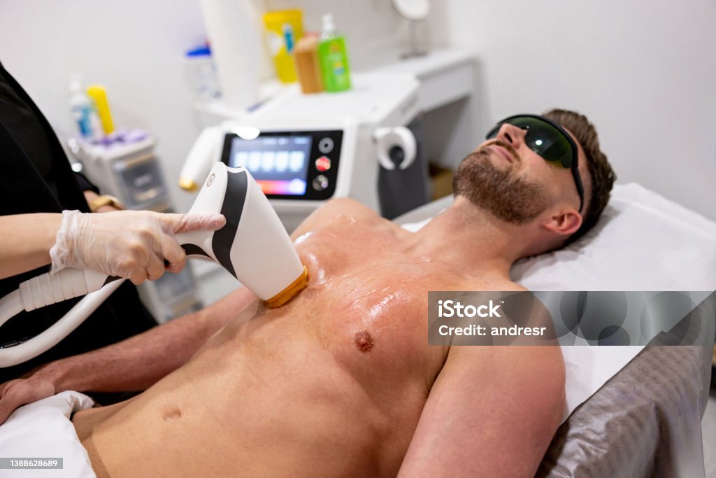 Man getting a laser hair removal on his chest Handsome man getting a laser hair removal on his chest - beauty treatment concepts Hair Removal Stock Photo