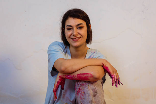 Beautiful smiling female artist in her small messy atelier