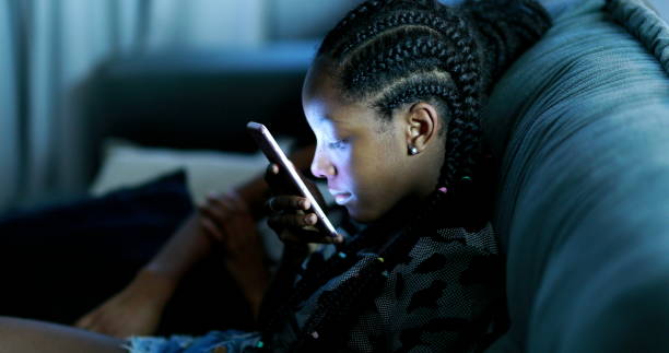 Black girl using smartphone at night stock photo