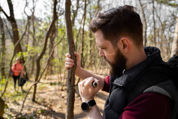 istock Man in wilderness in forest, leaving mark on the tree 1388630243