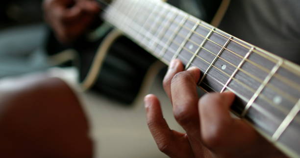 istock Black man hands playing guitar. African person practicing with musical instrument closeup hand 1388630427