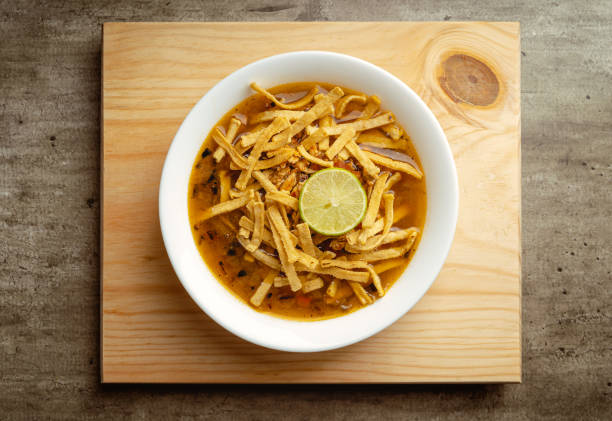 Traditional mexican lime soup with chicken on a wooden base
