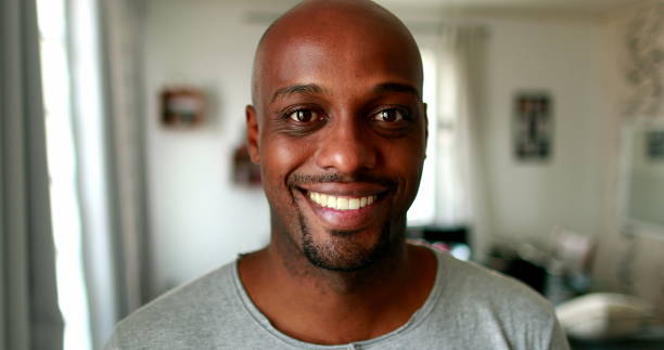 Black mixed race man smiling at camera indoors at home, casual person real people series stock photo