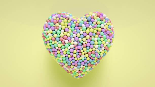 istock Heart Shaped Colorful Balls On Yellow - 3D Illustration 1388631880