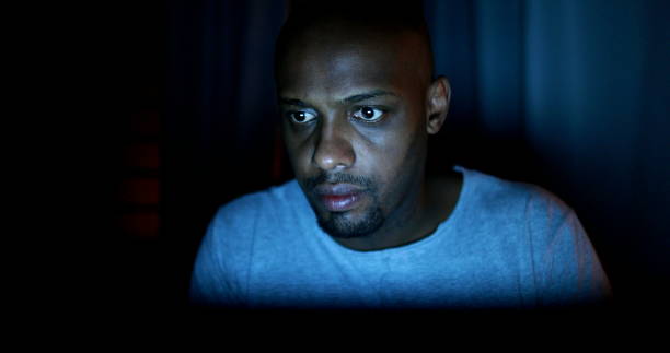 istock Black man face staring at laptop screen at night 1388633016