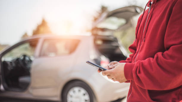잘생긴 젊은 히스패닉은 자신의 휴대 전화를 사용하여 자신의 차와 충돌. 도로 안전 개념 - car insurance auto accidents accident 뉴스 사진 이미지