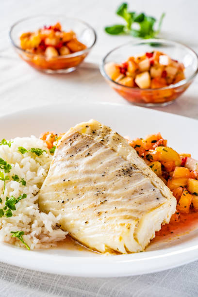 Roast cod fillet, boiled white rice and salsa stock photo