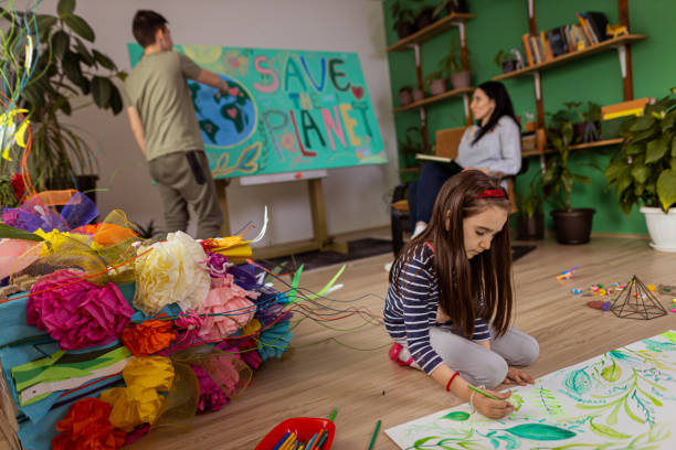 母親と弟と一緒にアートスタジオで葉のイラストを着色する小さな女の子 - child art childs drawing painted image ストックフォトと画像