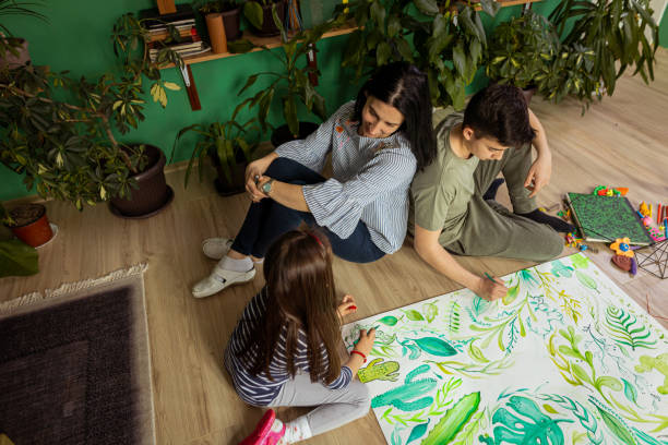 istock Mother watching her children drawing leaf symbols 1388637518