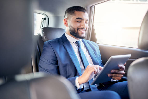 istock Shot of a young businessman using a digital tablet while travelling in a car 1388639006